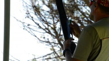 Hedefleyen ve skeet bir tüfek ateş tetikçi adam