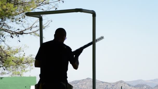 Shooter in position of skeet championship aiming and shooting a rifle — Stock Video