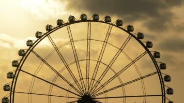 Dönme dolap, bulutlu gün batımında gyrating