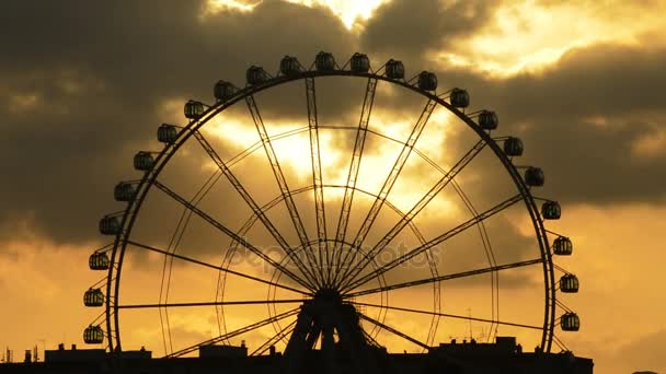 Ferris wheel spinning at sunset with clouds in sky — Stock Video