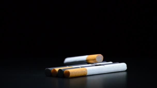 Sigaretten tabak draaien op zwarte achtergrond — Stockvideo