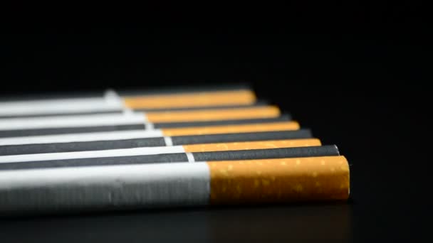 Табачные сигареты вращаются на черном фоне — стоковое видео