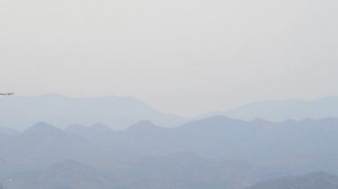 Gün batımında dağlar arasındaki iniş uçak