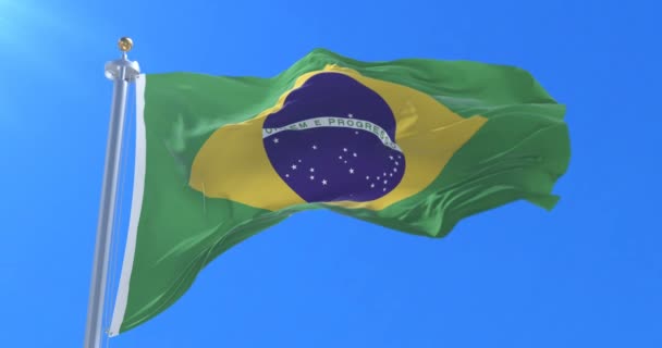 Flag of Brazil waving at wind in slow with blue sky, loop