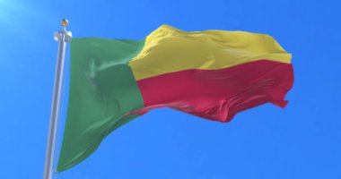 Benin bayrak sallayarak rüzgarda, yavaş mavi gökyüzü ile döngü