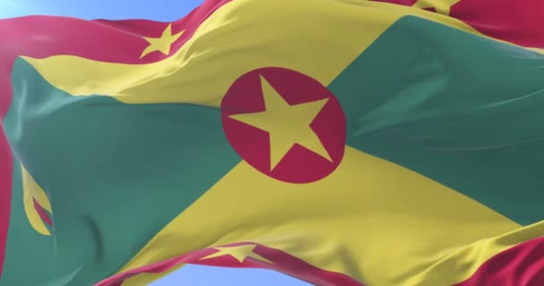 Flagga av Grenada viftande på vinden i långsamt i blå himmel, slinga — Stockvideo