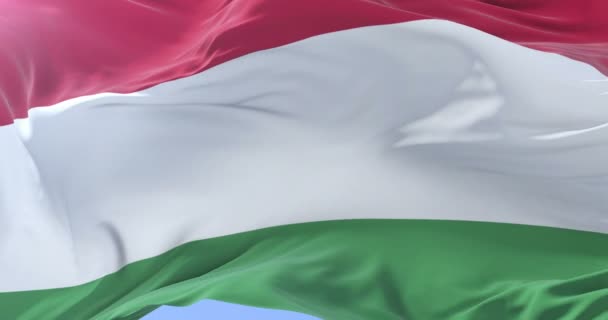 Flaga Węgier macha na wiatr w powolny w błękitne niebo, pętla — Wideo stockowe