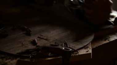 Luthier sandind iş yerinde ahşap bir planer ile yeni bir gitar arkası