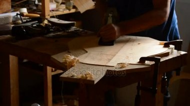 İş yerinde ahşap bir planer gitarla bir üst zımpara luthier