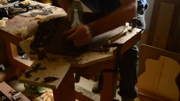 職場で木材の平面とギターの背面をサンディング弦楽器 — ストック動画