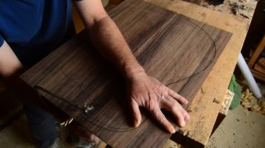 Luthier ahşap bir testere ile yeni bir klasik gitar üretimi için şekiller.