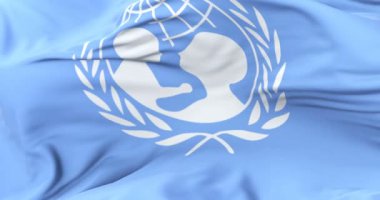 Mavi gökyüzünde yavaş, rüzgarda sallayarak UNICEF, bayrak, döngü
