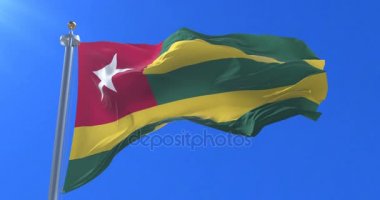 Togo bayrak sallayarak rüzgarda, yavaş mavi gökyüzü ile döngü