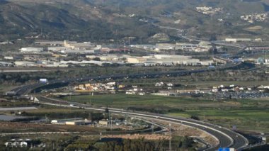 Günbatımında bir otoyol trafik ile üzerinde uçan uçak