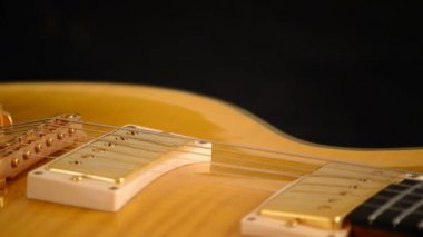 Köprü, dizeleri ve elektro gitar üzerinde gyrating pikap siyah arka plan