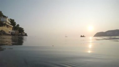 Günbatımı ve balıklar yarı batık bir fotoğraf makinesi ile Denizde yüzme plaj tekne balıkçılık içinde üç erkek görünümü
