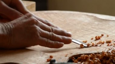 Luthier atölyede bir oyuk ile gitar kapağı oyuyor.