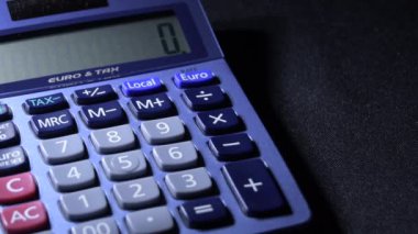 Hesap makinesi ile hesaplama yapan erkek parmağı işlemleri değiştirir
