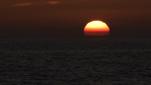 太陽が沈む夕日の海の地平線に隠れて — ストック動画