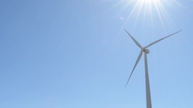 Yenilenebilir enerji türbini güneşli bir günde mavi gökyüzü ile hareket ediyor.