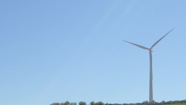 在阳光灿烂的日子里 可再生能源风力涡轮机在蓝天下转动叶片 — 图库视频影像