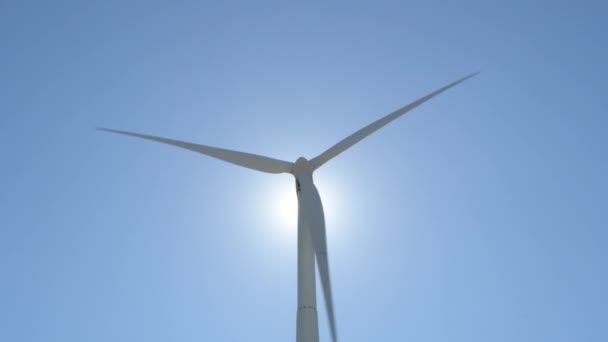 可再生能源风力涡轮机在阳光灿烂的蓝天背光下运行 — 图库视频影像