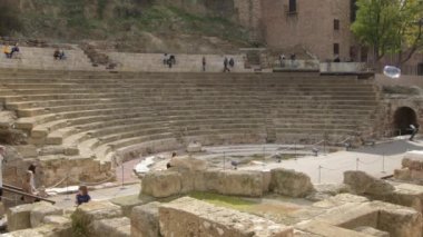 İspanya 'nın Malaga kentindeki antik Roma tiyatrosunu veya amfitiyatrosunu ziyaret eden insanlar