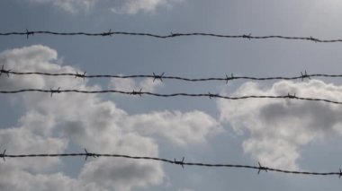 Gün batımında dikenli tellerle çevrili bulutlar
