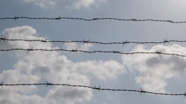 Gün batımında bulutlarla çevrili tel örgü, zaman aşımı