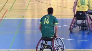 Tekerlekli sandalyedeki basketbol oyuncuları antrenmanda.