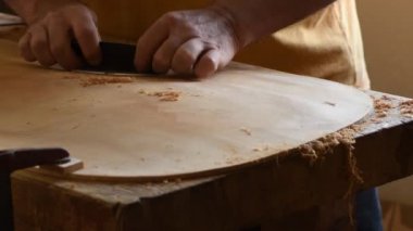 İş yerinde yeni bir kemanın kapağını zımparalıyor.