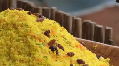 Büyük bir tabakta kuskus ve market yemekleri.