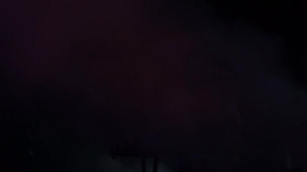 Silhouette d'un clavier entre fumée et lumières dans un concert 