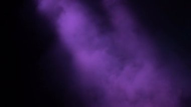 Bir konser sahnesinde renkli duman sütunları var.