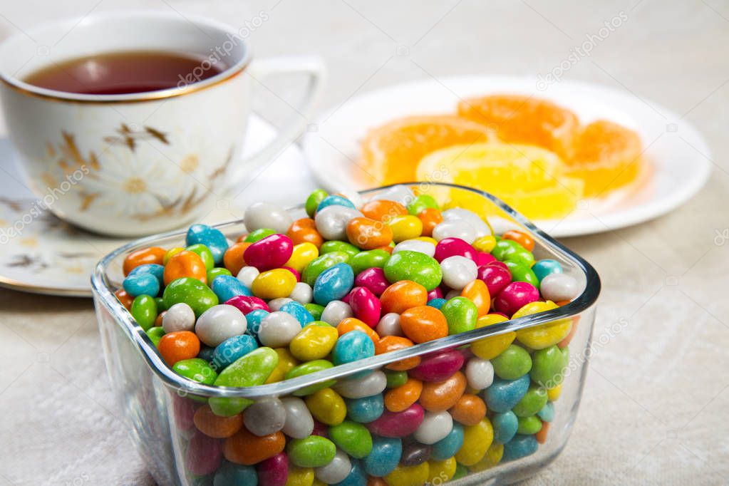 Jelly beans, tea cup and saucer with fruit jelly.