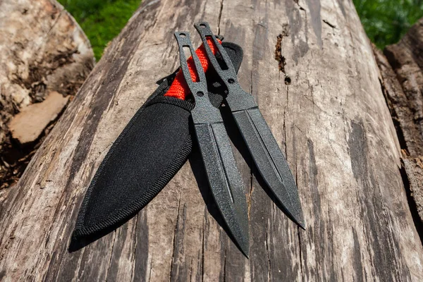 Photo of a throwing knife on a wooden background. Stainless stee