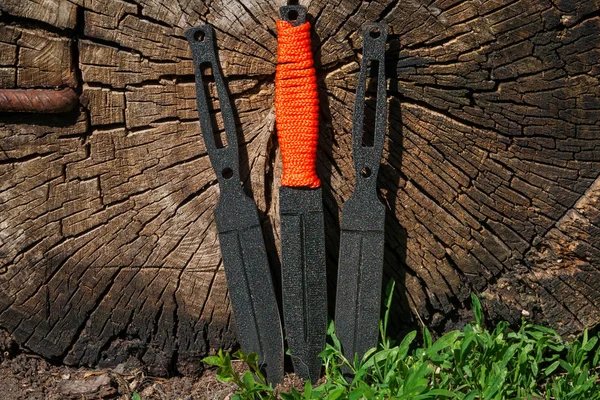 Photo of a throwing knife on a wooden background. Stainless stee