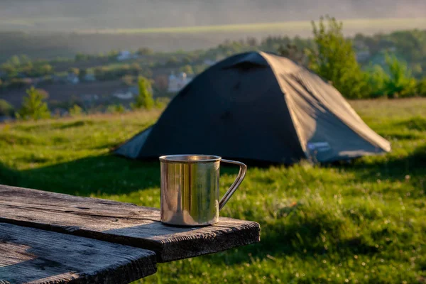 Çelik fincan bir turist çadır arka planda.