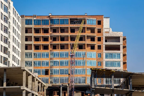 Work in progress on a new apartment block. Tall building under construction with cranes. Construction Site of New Building