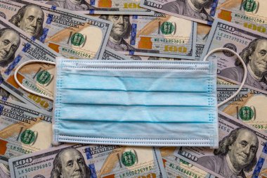 Amerika Birleşik Devletleri banknotları ve virüse karşı koruyucu bir maske. Coronovirüs ile ilişkili dünya ekonomik krizi.