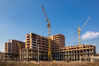 Yeni bir apartman bloğu üzerinde çalışıyoruz. Vinçlerle birlikte inşaat halindeki yüksek bina. Yeni Bina İnşaat Alanı