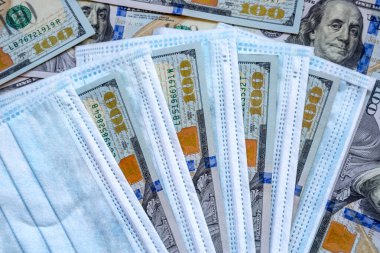 Amerika Birleşik Devletleri banknotları ve virüse karşı koruyucu bir maske. Coronovirüs ile ilişkili dünya ekonomik krizi.
