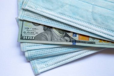 Amerika Birleşik Devletleri banknotları ve virüse karşı koruyucu bir maske. Coronovirüs ile ilişkili dünya ekonomik krizi.