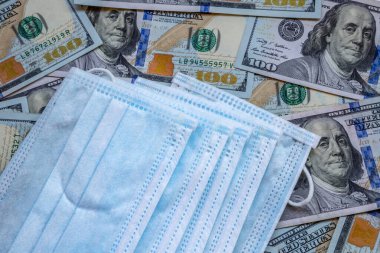 Amerika Birleşik Devletleri banknotları ve virüse karşı koruyucu bir maske. Coronovirüs ile ilişkili dünya ekonomik krizi.