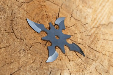 Shuriken (fırlatma yıldızı), geleneksel Japon Ninja soğuk silahı ahşap arka planda sıkışmış