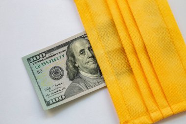 Amerika Birleşik Devletleri banknotları ve virüse karşı koruyucu bir maske. Coronovirüs ile ilişkili dünya ekonomik krizi.