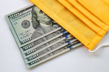 Amerika Birleşik Devletleri banknotları ve virüse karşı koruyucu bir maske. Coronovirüs ile ilişkili dünya ekonomik krizi.