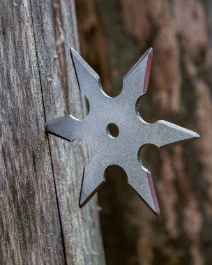 Shuriken (fırlatma yıldızı), geleneksel Japon Ninja soğuk silahı ahşap arka planda sıkışmış