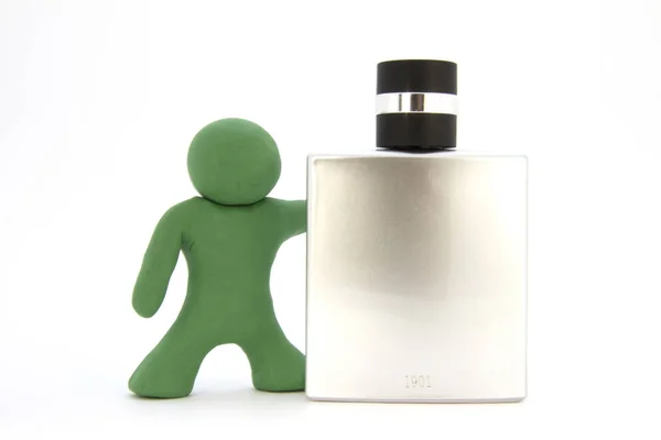 Green plasticine character and perfume bottle. Toiletries. Isolated over white background — Stock Photo, Image