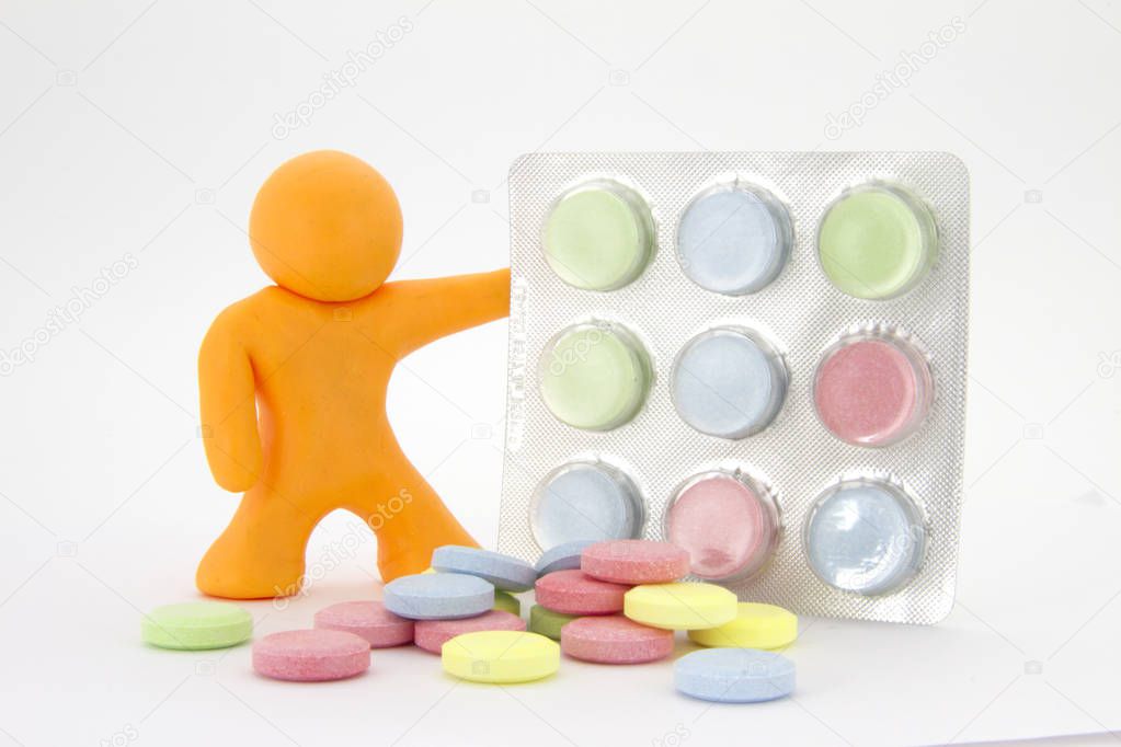 Orange plasticine character and colorful pills  tablets in the package. Pharmacy theme. Isolated on white background